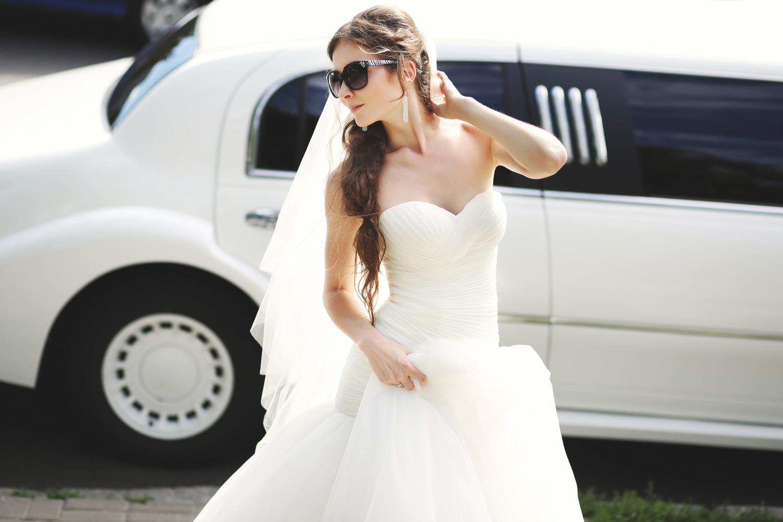 beautiful bride posing with white limo for wedding limo services Vancouver